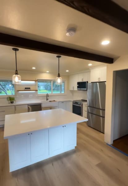 Modern kitchen remodeling with white cabinets, island and open concept design in Gilroy California
