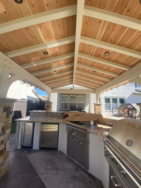 Covered patio construction with outdoor kitchen and seating area in California home