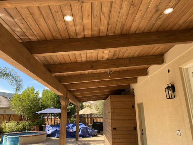 Covered patio with outdoor fireplace and seating area built by general contractor in California